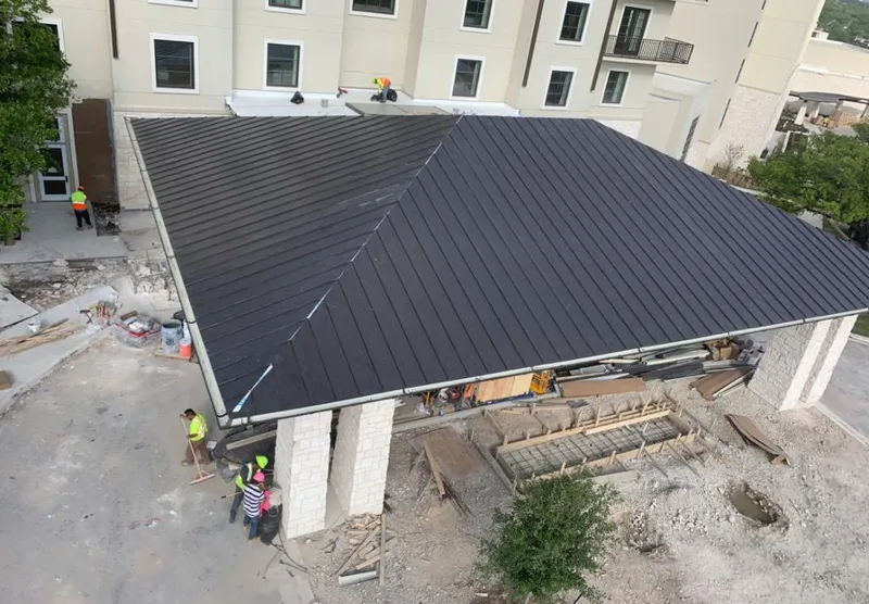 Metal roofing installation team working on a commercial building in Reisterstown